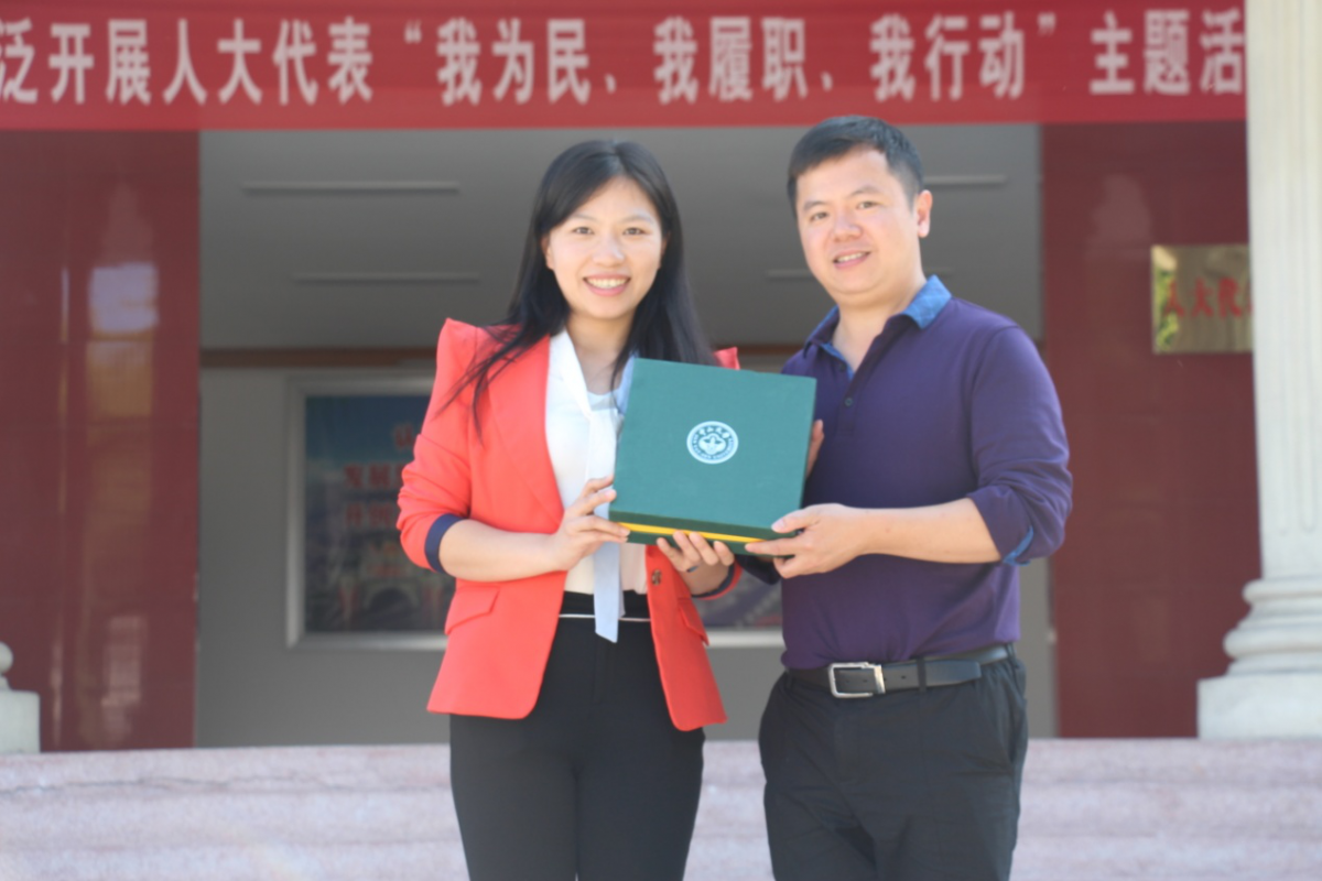 中山大学历史学系副教授李欣荣向茶阳镇政府副书记黄小玲（校友）赠送母校纪念品