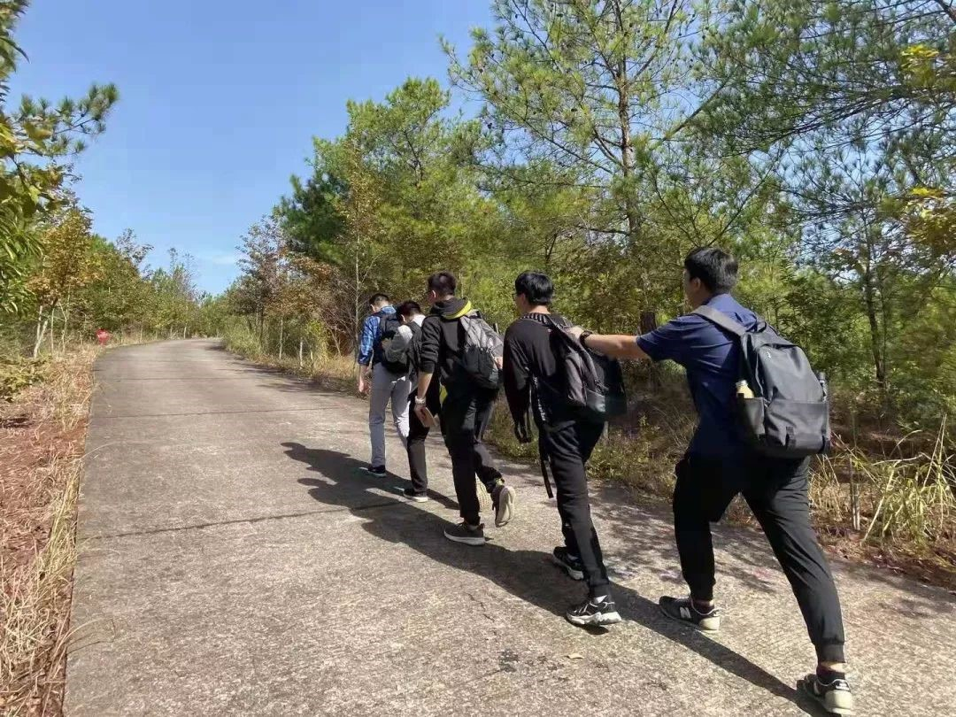 陈喆老师开登山之路,后有四名学生搭肩前行